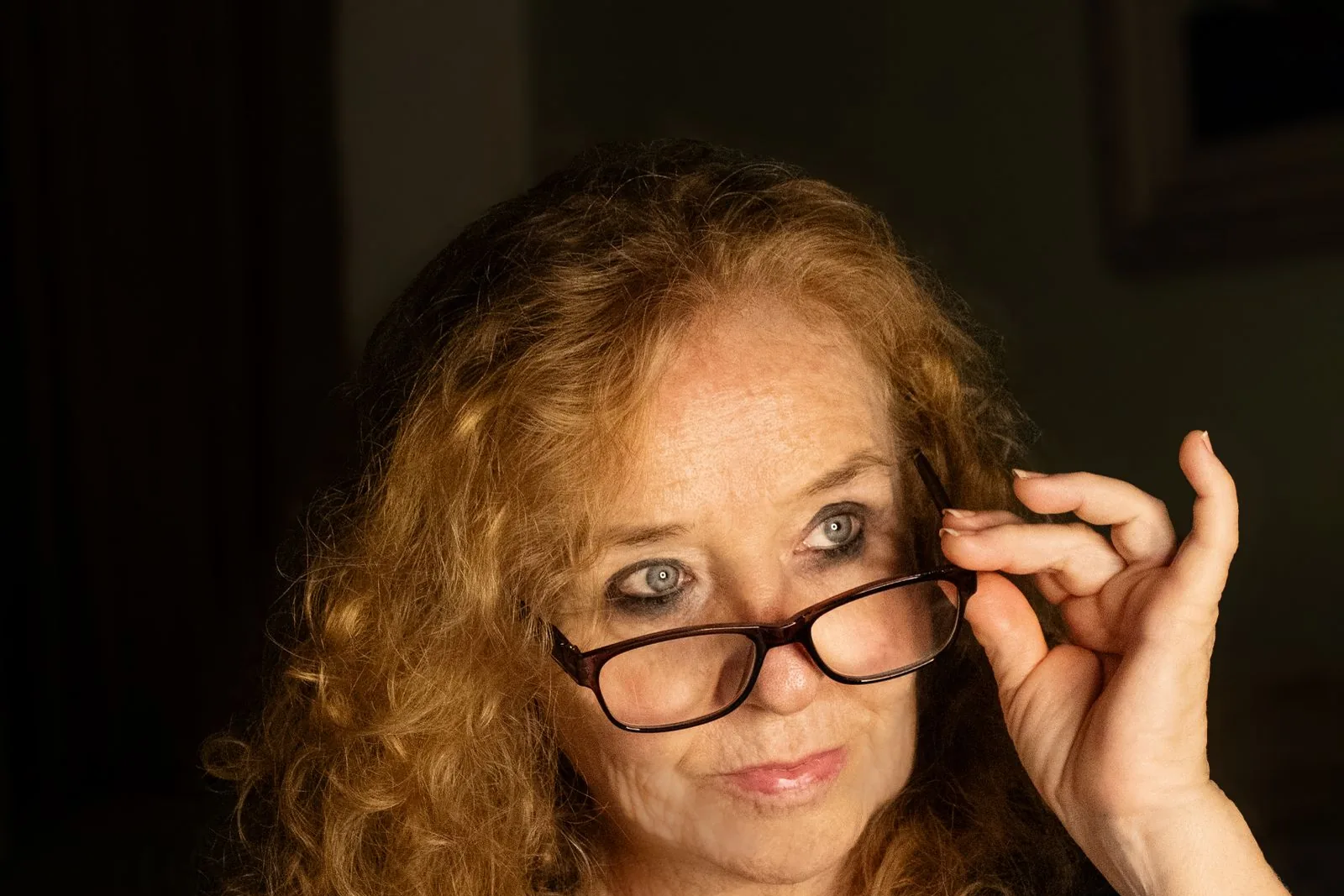 Woman with glasses reading a book at home